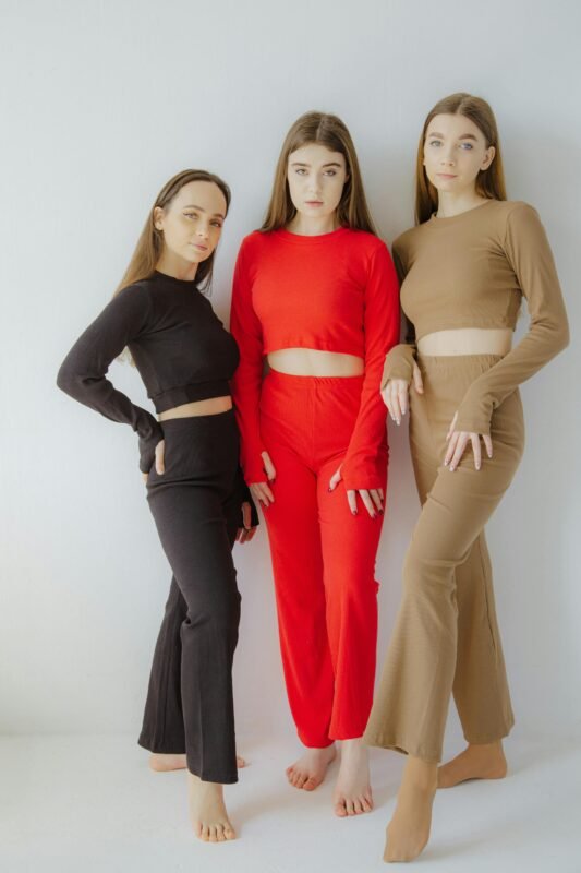 Three women in trendy matching outfits posing against a white background.